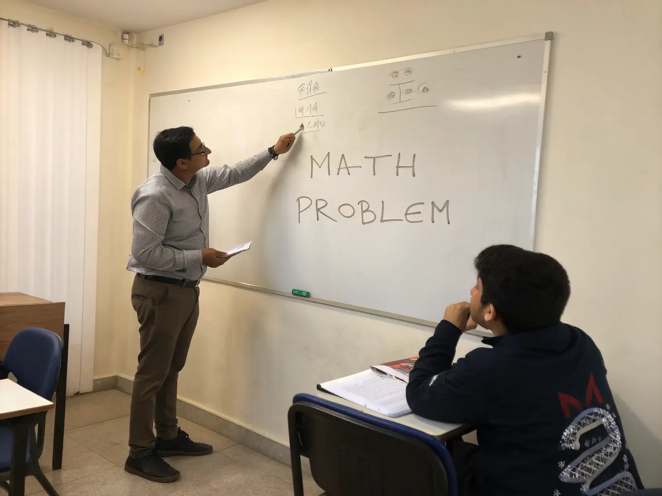 A photograph of Nekoda tutoring a student in mathematics, showcasing a supportive and engaging learning environment with textbooks and a whiteboard in the background.
